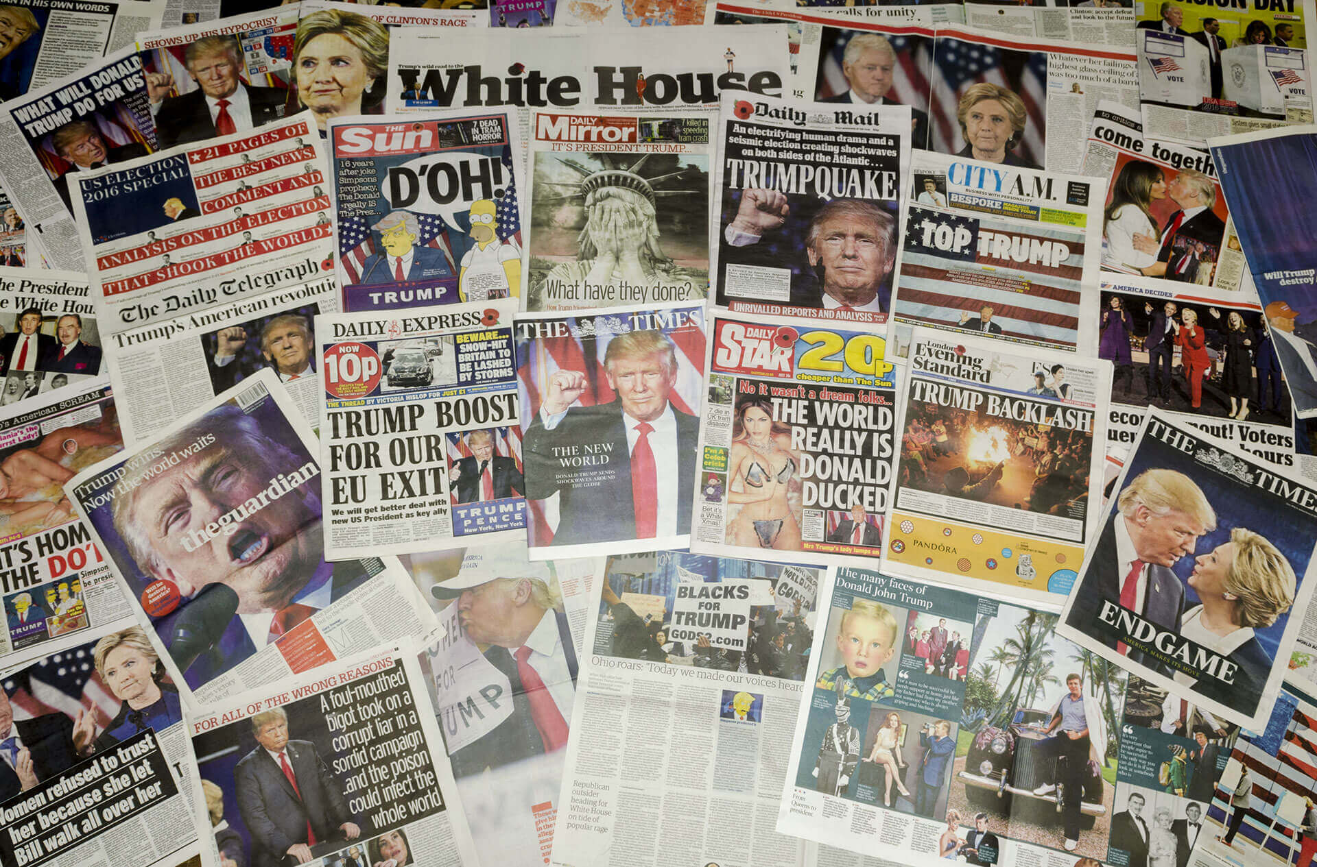 Collage of international newspaper front pages reacting to Donald Trump’s 2016 U.S. presidential election victory. Headlines include phrases like ‘TRUMPQUAKE,’ ‘TRUMP BOOST FOR OUR EU EXIT,’ and ‘THE WORLD REALLY IS DONALD DUCKED,’ alongside images of Trump, Hillary Clinton, and symbolic visuals like the Statue of Liberty. The coverage ranges from shock and satire to political analysis, reflecting global reactions to the unexpected election outcome.